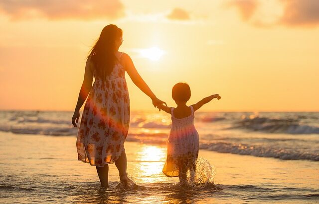 Dia das mães no e-commerce - Mãe andando de mãos dadas com a filha na praia